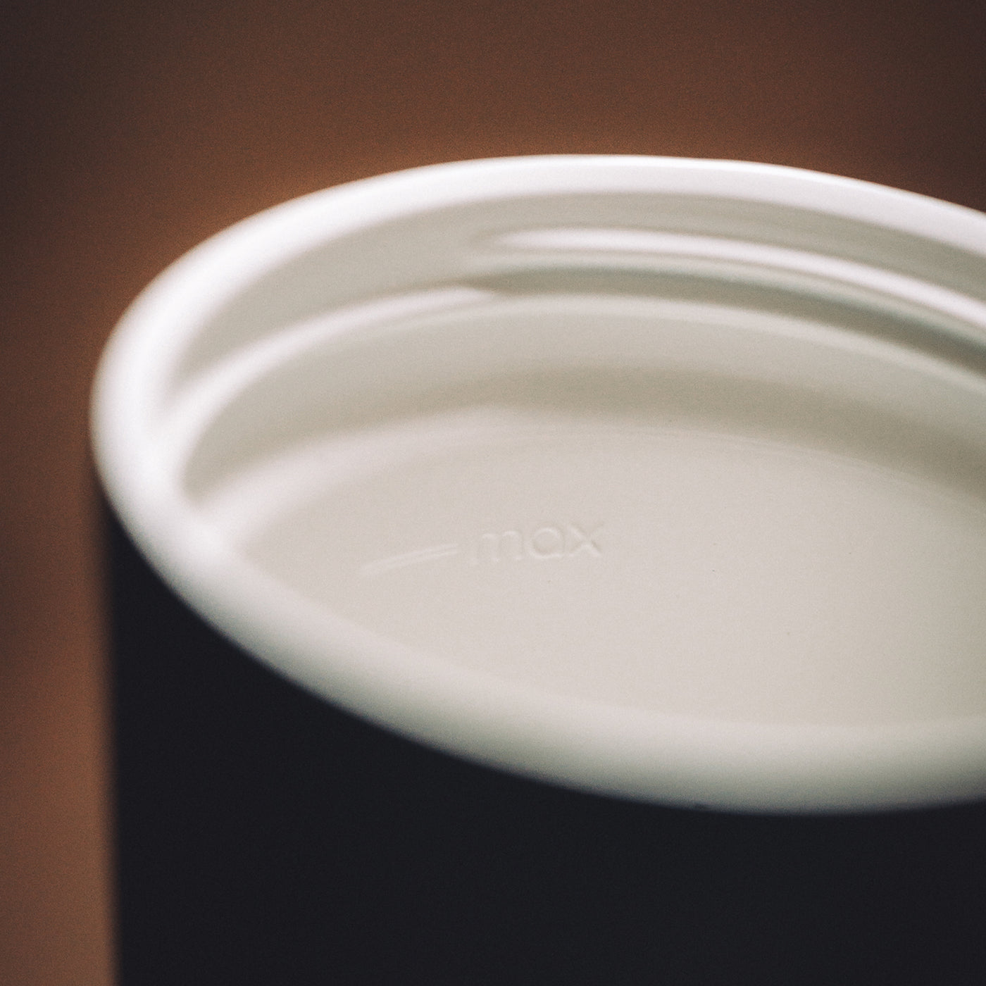 Close-up inside a bru travel mug showing the white ceramic-lined interior and embossed max fill line